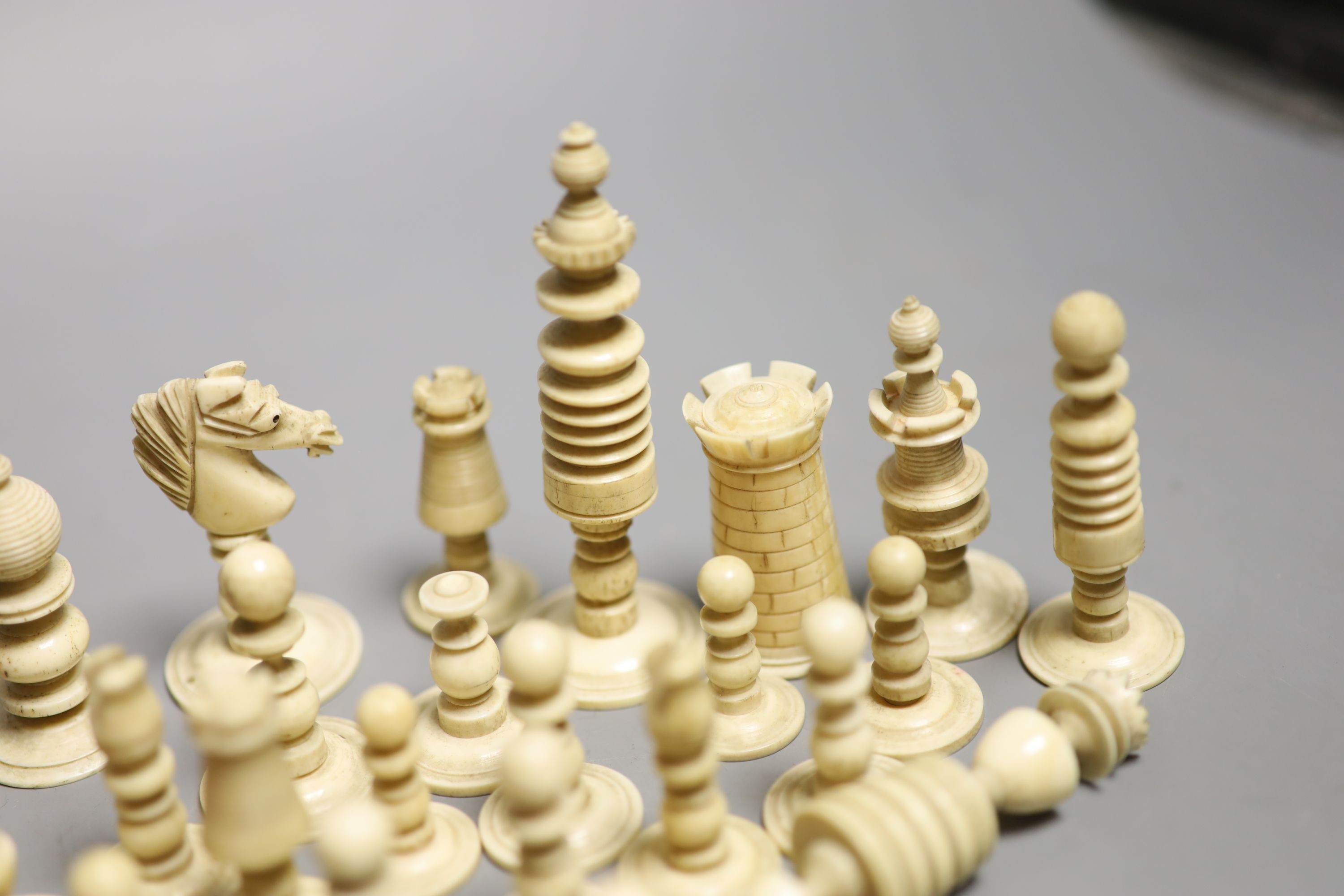 A set of 19th century red stained and natural bone chess pieces and a collection of etched mother of pearl bezique counters